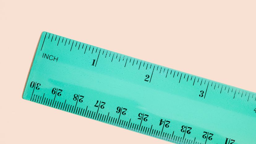 Directly above view of green ruler on a peach-colored background.