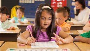 Little girl in class counting on her fingers