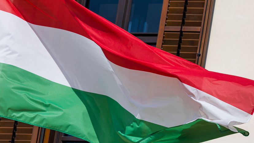 Hungarian flag, horizontal stripes of red, then white, then green, outside a window