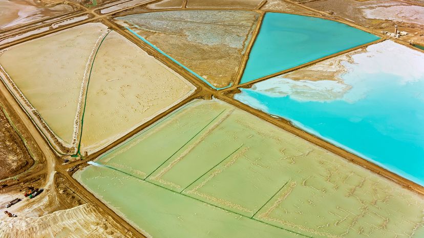 Plots of teal, green, dirt, and sand in the desert