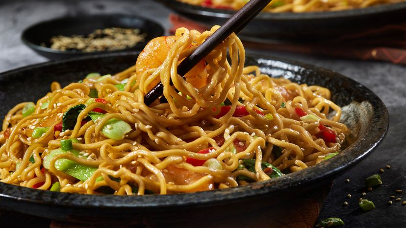 Black bowl of Asian-style noodles with vegetables