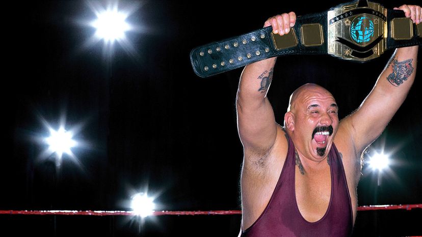 Wrestler holding a champion belt over his head