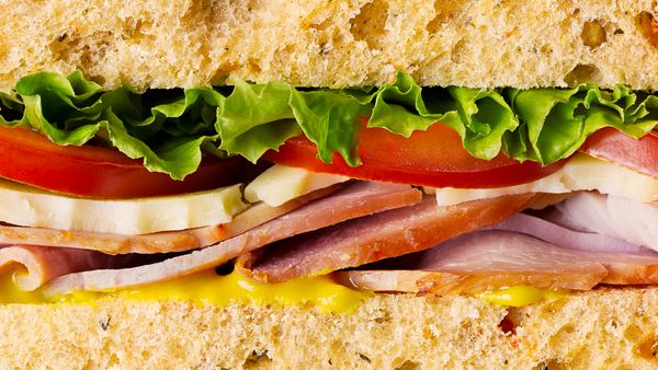 Ham sandwich with tomatoes, cheese, mustard and lettuce