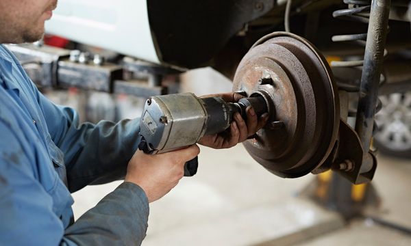 Garage mechanic removing hub nut