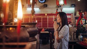 Oman kneeling in prayer at a Buddhist temple