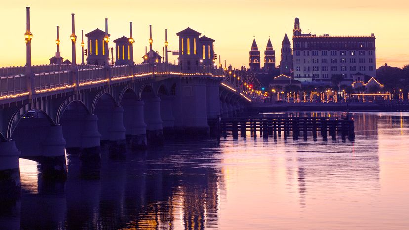 Sunset view of a bridge over a river and an old city in the distance