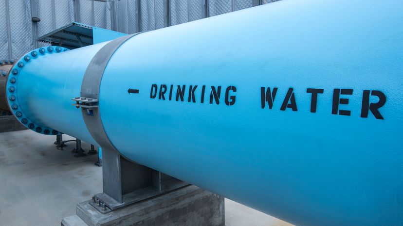 Drinking water exits a desalination plant in a large, blue pipe