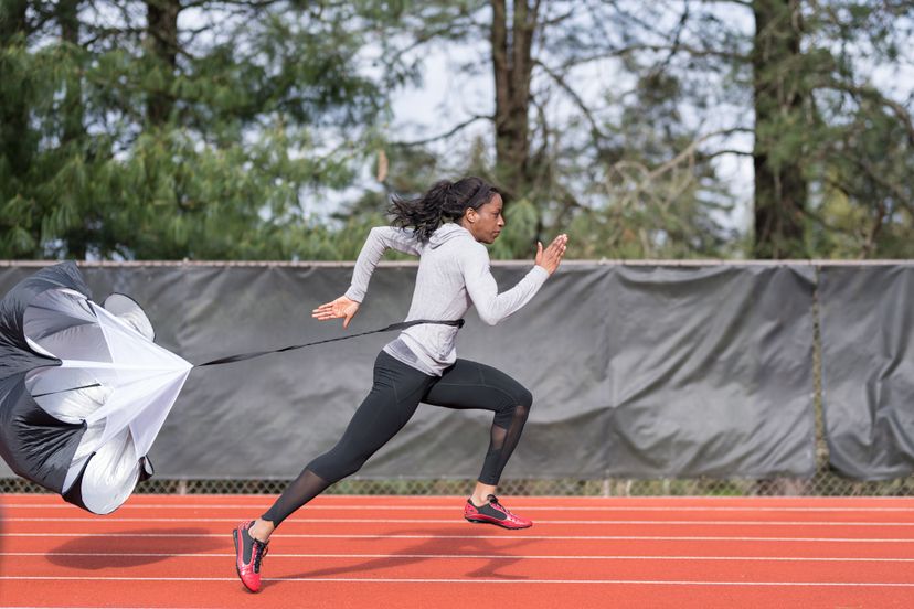 An athlete runs sprint drills on a stadium track.