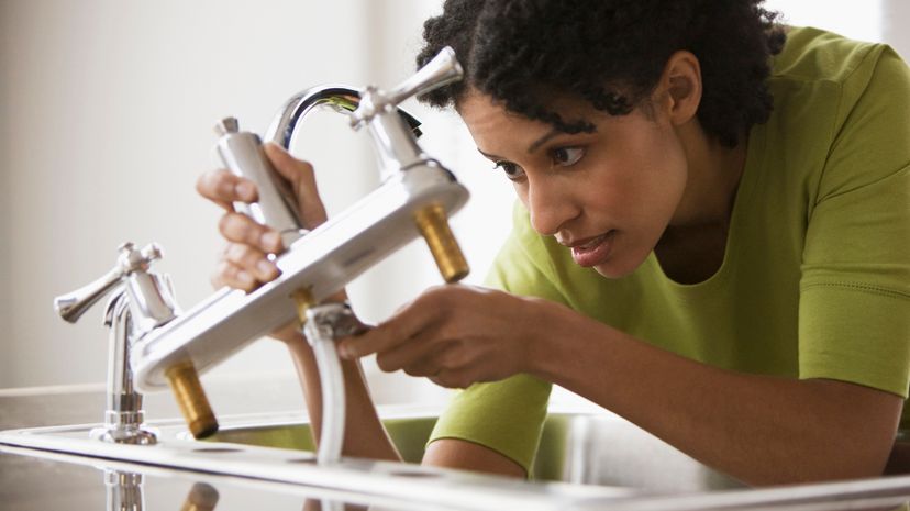 Woman using a wrench on a faucet system