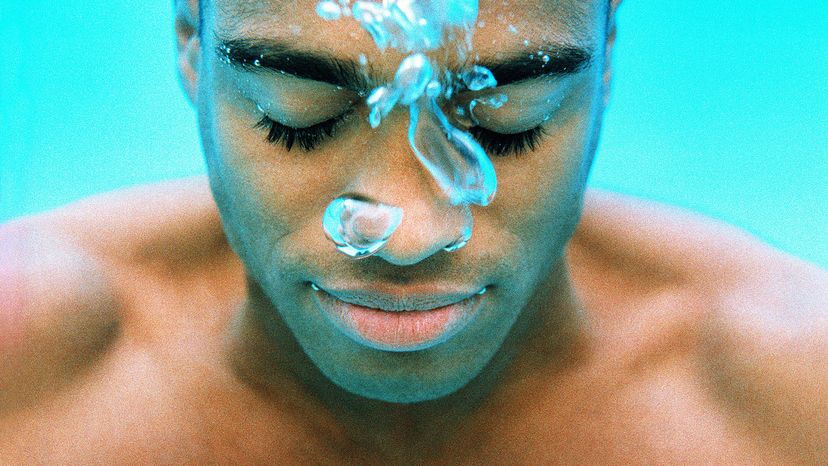 Man with his eyes closed while he holds his breath underwater