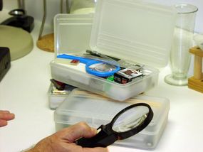 This magnifying lens has been used to examine hundreds of supposed holy relics, monster footprints and physical traces left by ghosts. In the background are several of the modules Nickell uses to put together an investigator's tool kit appropriate to each case.