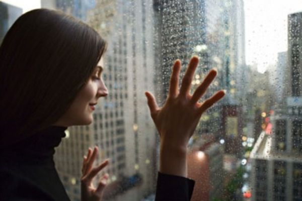 Woman looking out glass window