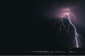 photograph of lightning flash over city 
