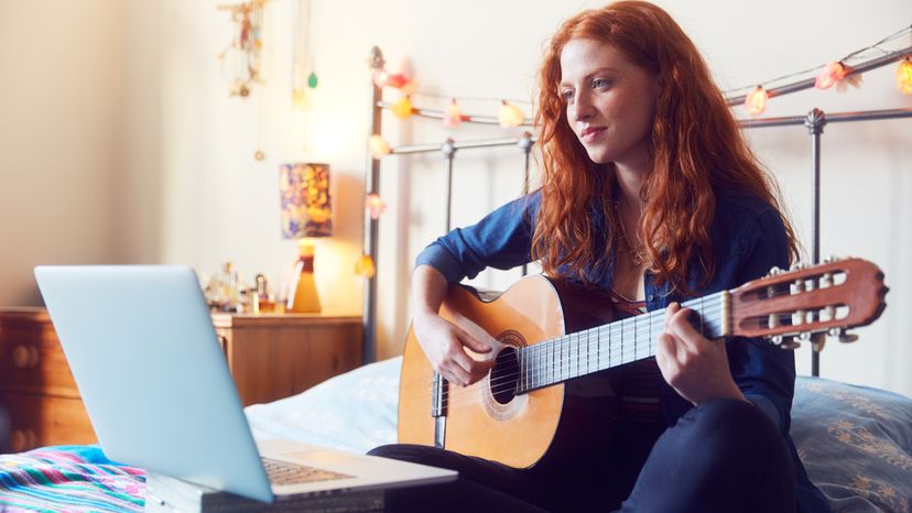 A girl with a guitar and laptop