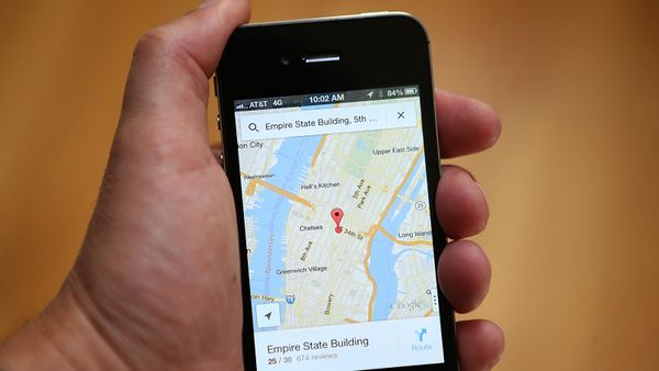 Smartphone pointing to map in human hand: travel!