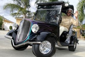 Lillie Lipscomb waves as she drives her golf cart, a fiberglass replica of a 1934 Ford, from her driveway in The Villages, Fla.