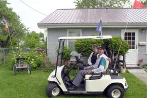Gary Knight, 48, sits in his golf cart with his mother, Joann Hall, at their home in Sweet Springs, Mo. For the last six years Knight, who has cerebral palsy, has used a golf cart as a way to get around in the small town.