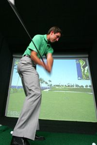 Charl Schwartzel of South Africa swings at a golf simulator in Singapore where the Barclays Singapore Open golf tournament is held.