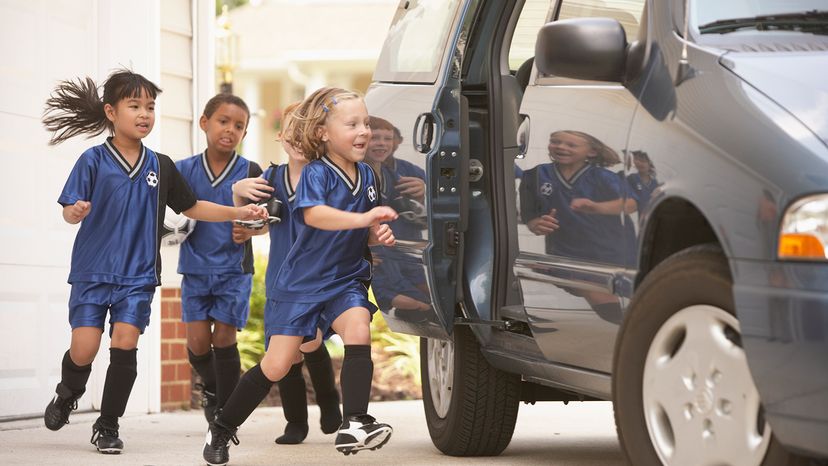 Kids in soccer uniforms getting into minivan