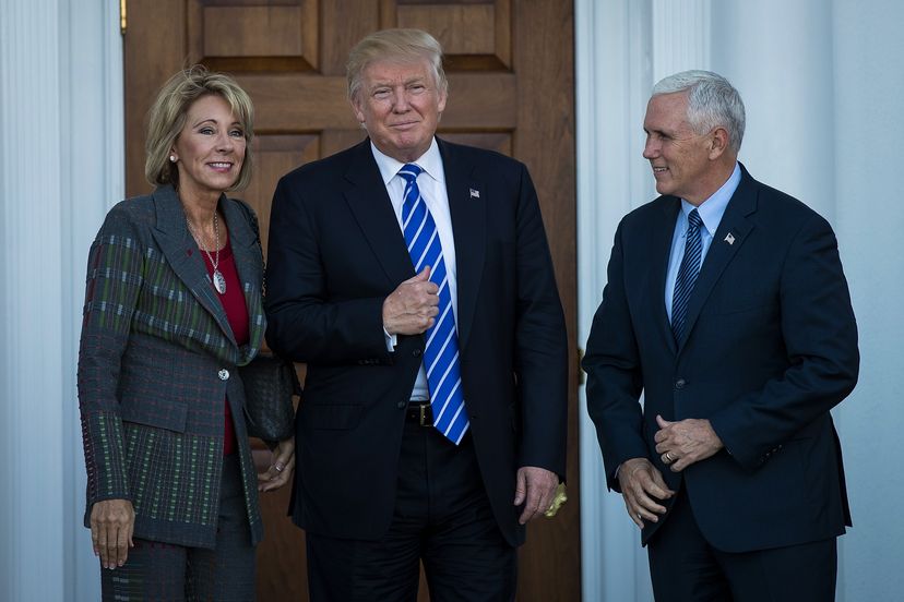 Betsy DeVos, President Donald Trump's pick for Secretary of Education, poses for a photo with Trump and Vice President Mike Pence.