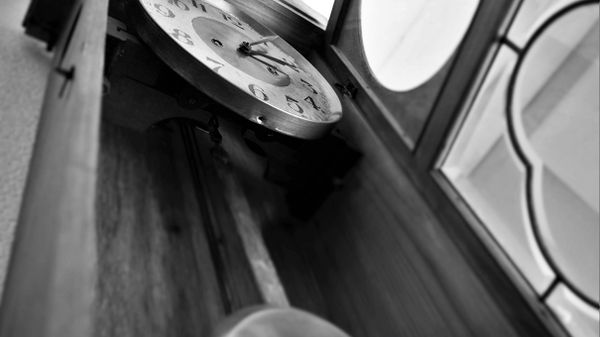 Time ticks by on the wooden clock indoors.