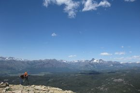 picture of man taking pictures of mountains from cliff edge