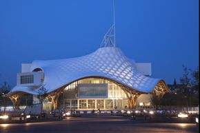 坂茂的另一个项目，法国蓬皮杜-梅斯中心。潘和让·德·加斯汀共同设计了这座现代艺术博物馆，并于2010年由尼古拉·萨科齐主持开幕仪式。时髦屋顶的横梁是由层压木材制成的。＂border=