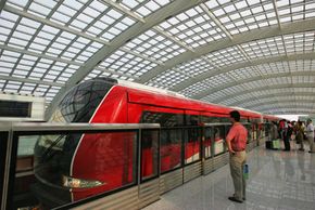 在北京首都国际机场，乘客们等待登上新机场快线列车。经过7年的建设，北京三条新地铁线正式开通。＂width=