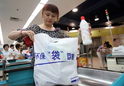 A woman in Wuhan, China puts her groceries into a reusable bag.