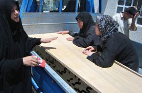 伊拉克妇女,穿着黑色,哀悼一个相对的巴古拜城外的尸体被发现在2008年6月。看到更多的情感图片。”width=