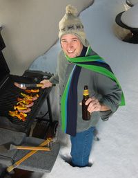 Happy man grilling in the snow.