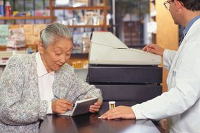 elderly woman writes check