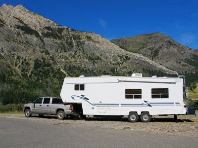A truck and fifth wheel camper stopped at a pull-off.