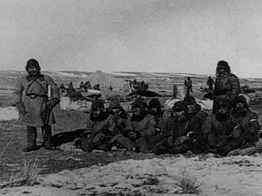 Japanese soldiers stand guard over eight Chinese prisoners in Mongolia during the Imperial Army's 1941 Winter Hygienic Research program.