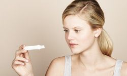 woman looking at pregnancy test