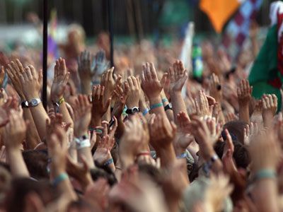 Cheering crowd celebrating with raised hands.