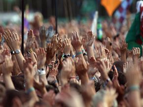 Cheering crowd celebrating with raised hands.