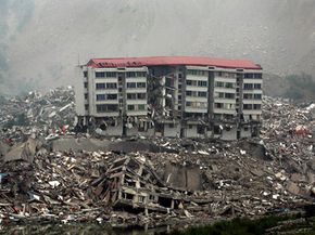 在中国西南部四川省北川县，救援人员在倒塌建筑的废墟中搜寻幸存者。查看更多自然灾害的图片。＂width=