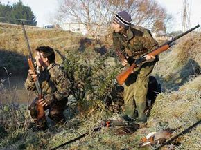 The hunter on the left is using his call to lure ducks into shooting range.