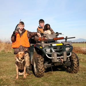 Smiling child and dog in off-road vehicle outdoors.