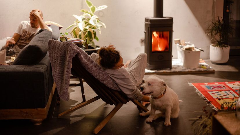 couple sitting by fire with dog
