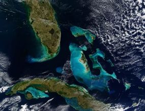 This image from a NASA satellite shows the coastline of the Bahamas, Florida and Cuba. The banks are shallow coral reefs that reflect light through the ocean, giving it a bright blue color.