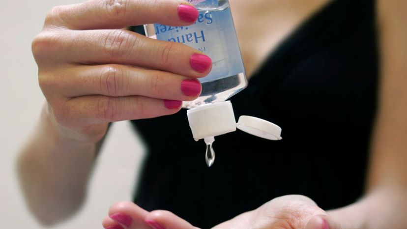 woman applying hand sanitizier