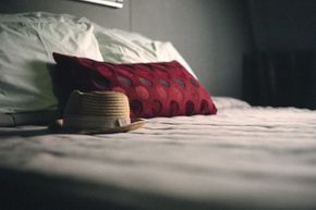 While putting your hat down on a bed might not conjure up evil spirits, it may transfer head lice.