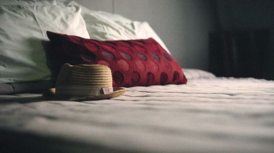 Why is it considered unlucky to leave a hat on the bed?