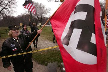 Adults celebrating patriotism outdoors with an American flag.