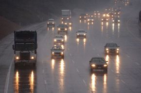Headlights are reflected on the rain slick freeway during a storm in Inglewood, Calif.