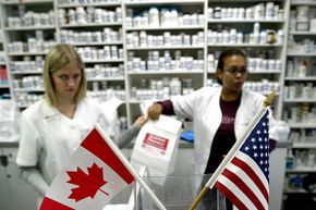 Canadian and American flags fly as Canadian pharmacists handle prescription drugs for a group of Minnesota senior citizens in 2003. Even though it is now technically illegal, many still Americans drive to Canada to buy cheaper drugs.