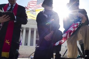 Demonstrators pray outside the U.S. Supreme Court on day three of oral arguments over the constitutionality of the Patient Protection and Affordable Care Act on March 28, 2012.