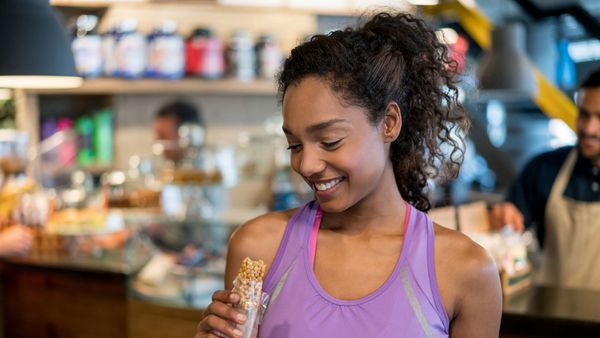 exerciser eating protein bar